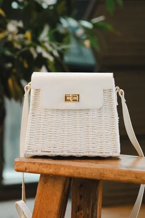 Amici Ollie Rattan Crossbody Tasche in .